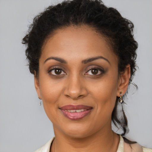 Joyful black young-adult female with short  brown hair and brown eyes