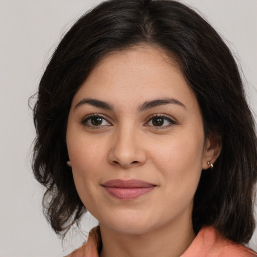 Joyful latino young-adult female with medium  brown hair and brown eyes