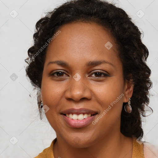 Joyful black young-adult female with long  brown hair and brown eyes