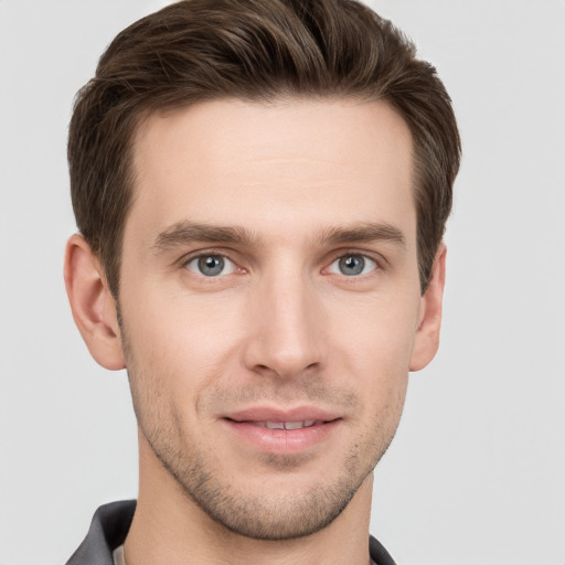 Joyful white young-adult male with short  brown hair and grey eyes