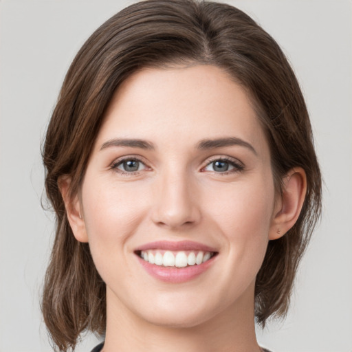 Joyful white young-adult female with medium  brown hair and green eyes