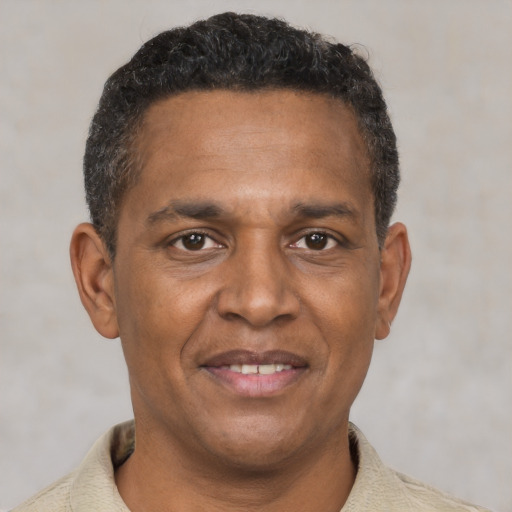 Joyful black adult male with short  brown hair and brown eyes