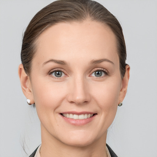 Joyful white young-adult female with medium  brown hair and grey eyes