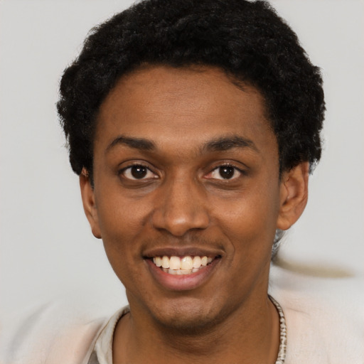 Joyful black young-adult male with short  black hair and brown eyes