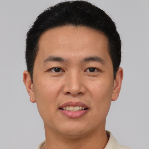 Joyful asian young-adult male with short  black hair and brown eyes