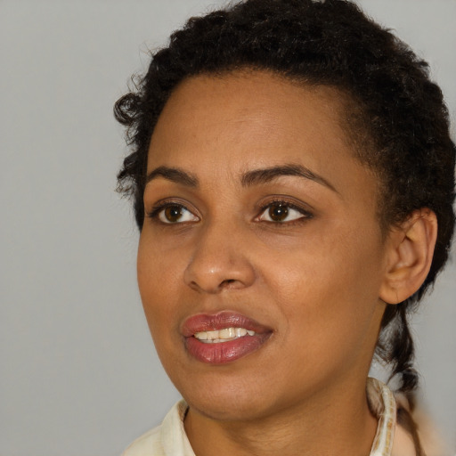 Joyful black young-adult female with short  brown hair and brown eyes