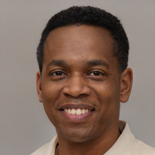 Joyful black young-adult male with short  black hair and brown eyes