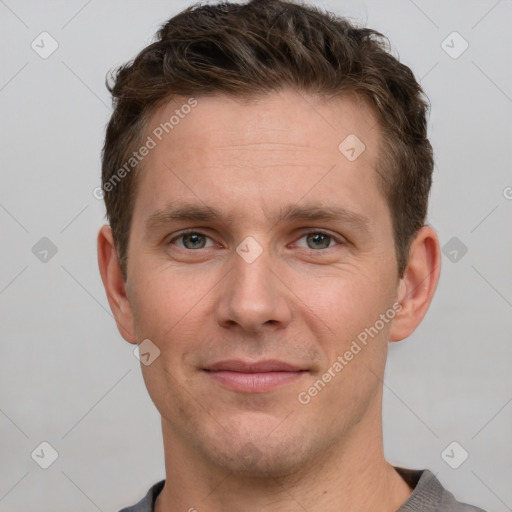 Joyful white young-adult male with short  brown hair and grey eyes