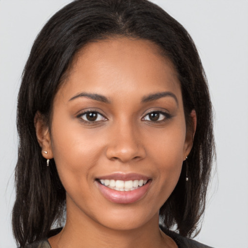 Joyful latino young-adult female with medium  brown hair and brown eyes