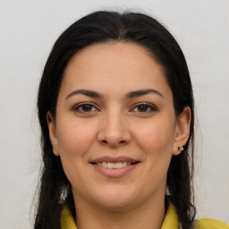 Joyful latino young-adult female with long  brown hair and brown eyes