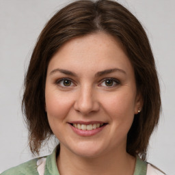 Joyful white young-adult female with medium  brown hair and green eyes