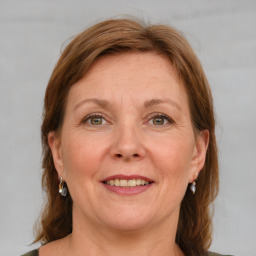 Joyful white adult female with medium  brown hair and blue eyes