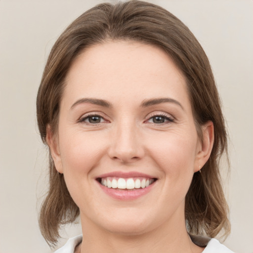 Joyful white young-adult female with medium  brown hair and green eyes