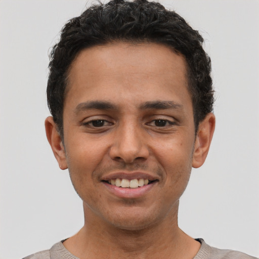 Joyful latino young-adult male with short  black hair and brown eyes