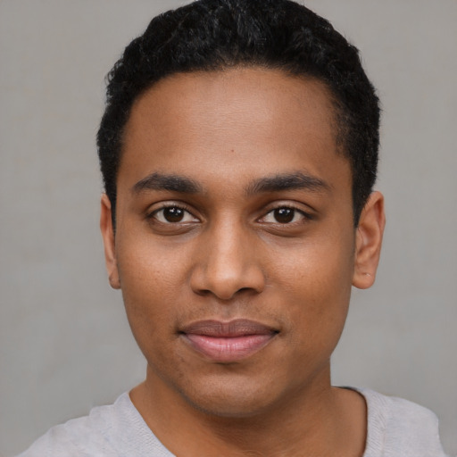 Joyful black young-adult male with short  black hair and brown eyes