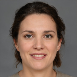 Joyful white adult female with medium  brown hair and brown eyes