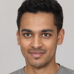 Joyful latino young-adult male with short  black hair and brown eyes