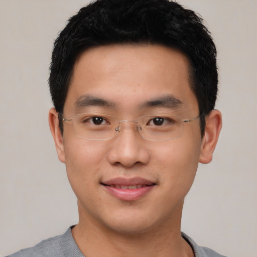 Joyful asian young-adult male with short  black hair and brown eyes