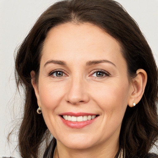 Joyful white adult female with long  brown hair and brown eyes