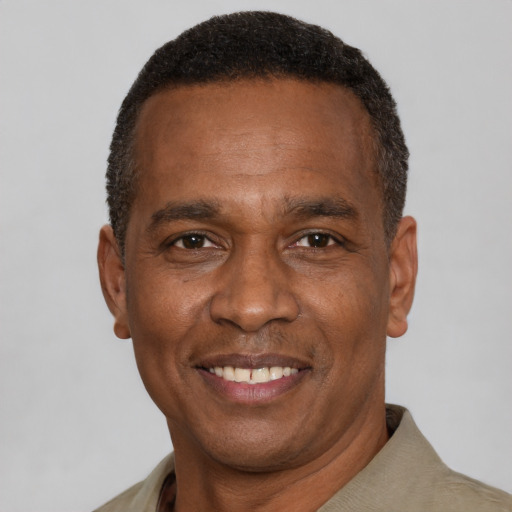 Joyful black adult male with short  black hair and brown eyes