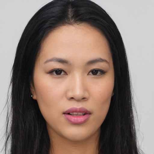 Joyful asian young-adult female with long  black hair and brown eyes