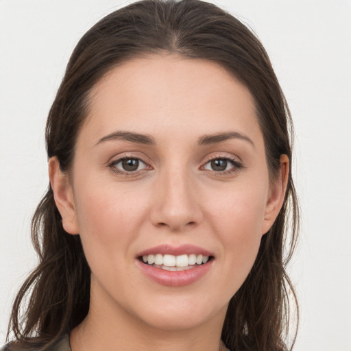 Joyful white young-adult female with long  brown hair and grey eyes