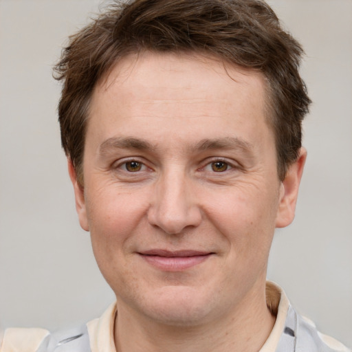 Joyful white adult male with short  brown hair and grey eyes