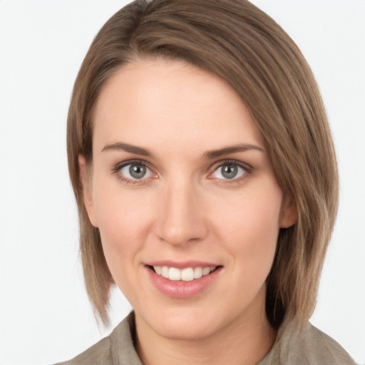 Joyful white young-adult female with medium  brown hair and grey eyes