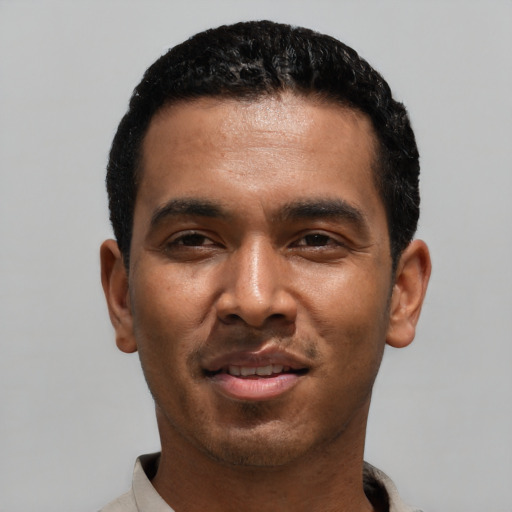 Joyful black young-adult male with short  black hair and brown eyes