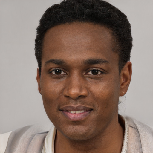 Joyful black young-adult male with short  black hair and brown eyes