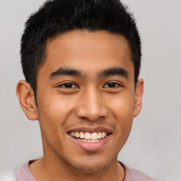 Joyful latino young-adult male with short  brown hair and brown eyes