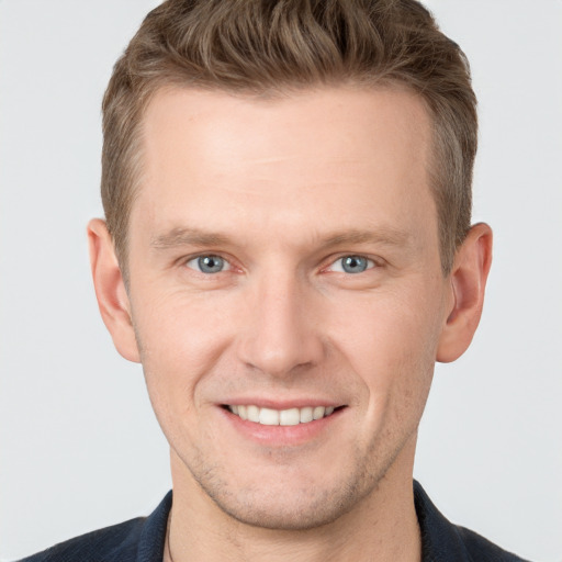 Joyful white young-adult male with short  brown hair and grey eyes