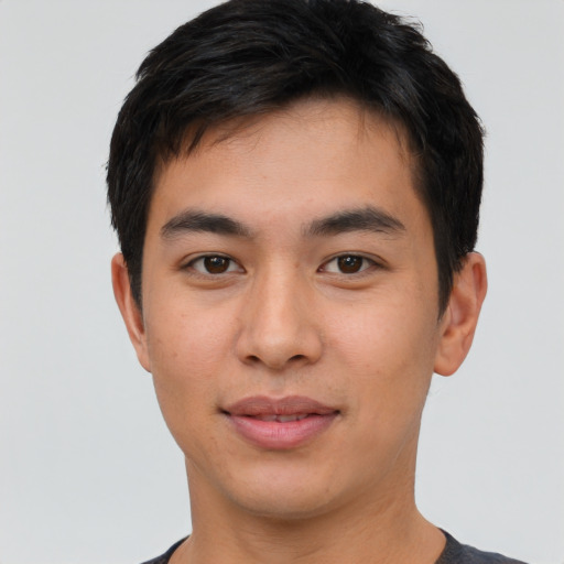 Joyful asian young-adult male with short  brown hair and brown eyes