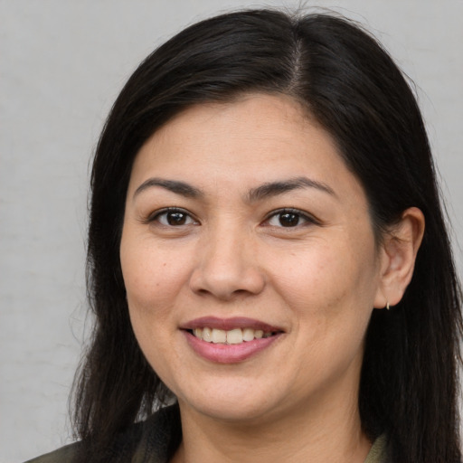 Joyful asian young-adult female with long  brown hair and brown eyes