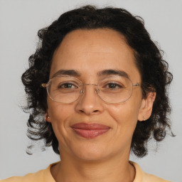 Joyful latino adult female with medium  brown hair and brown eyes