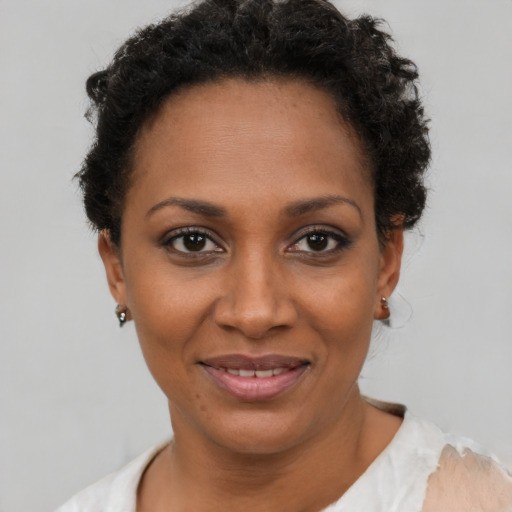 Joyful black young-adult female with short  brown hair and brown eyes