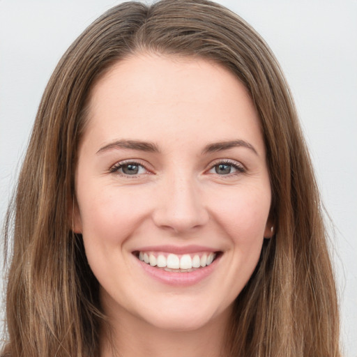 Joyful white young-adult female with long  brown hair and green eyes