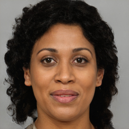 Joyful black adult female with medium  brown hair and brown eyes