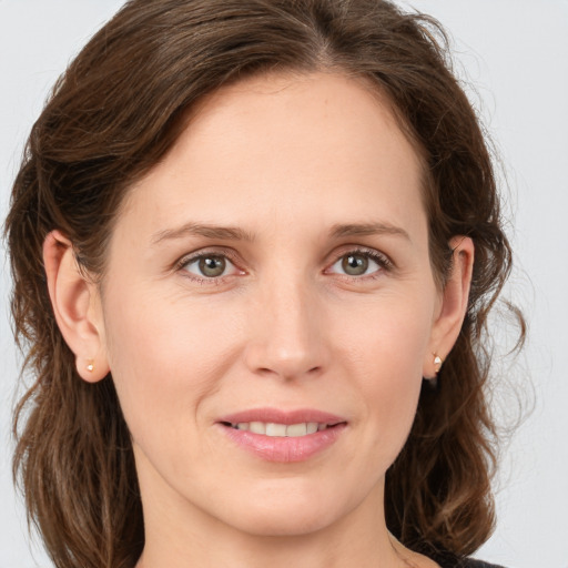 Joyful white young-adult female with medium  brown hair and green eyes