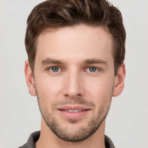 Joyful white young-adult male with short  brown hair and grey eyes