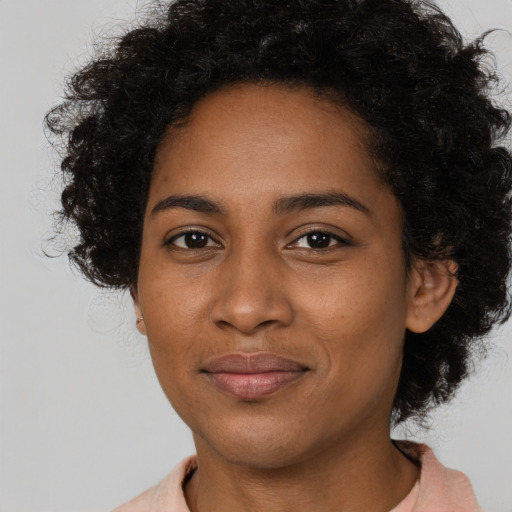 Joyful black young-adult female with short  brown hair and brown eyes