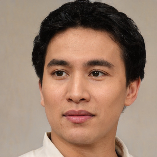 Joyful white young-adult male with short  black hair and brown eyes