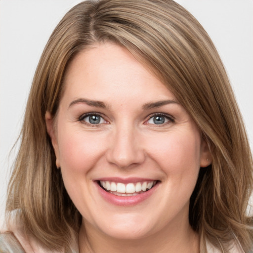 Joyful white young-adult female with medium  brown hair and green eyes