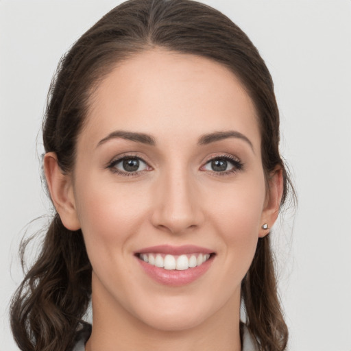 Joyful white young-adult female with long  brown hair and grey eyes