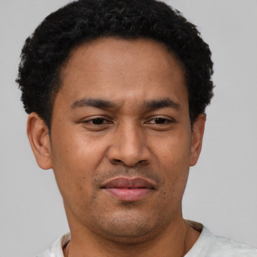 Joyful latino adult male with short  brown hair and brown eyes