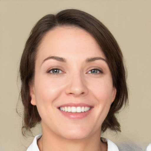 Joyful white young-adult female with medium  brown hair and green eyes