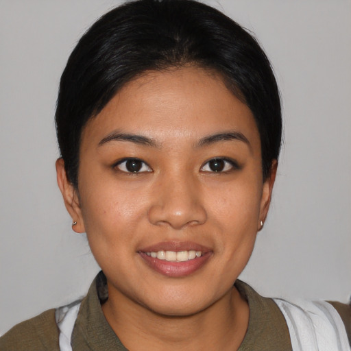 Joyful latino young-adult female with short  black hair and brown eyes