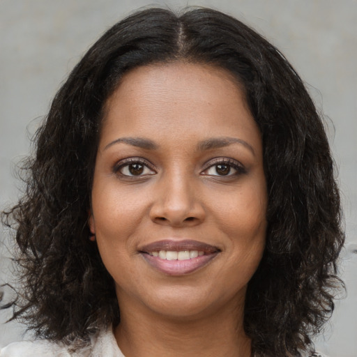 Joyful black young-adult female with medium  brown hair and brown eyes