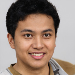 Joyful latino young-adult male with short  brown hair and brown eyes