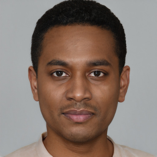 Joyful black young-adult male with short  black hair and brown eyes